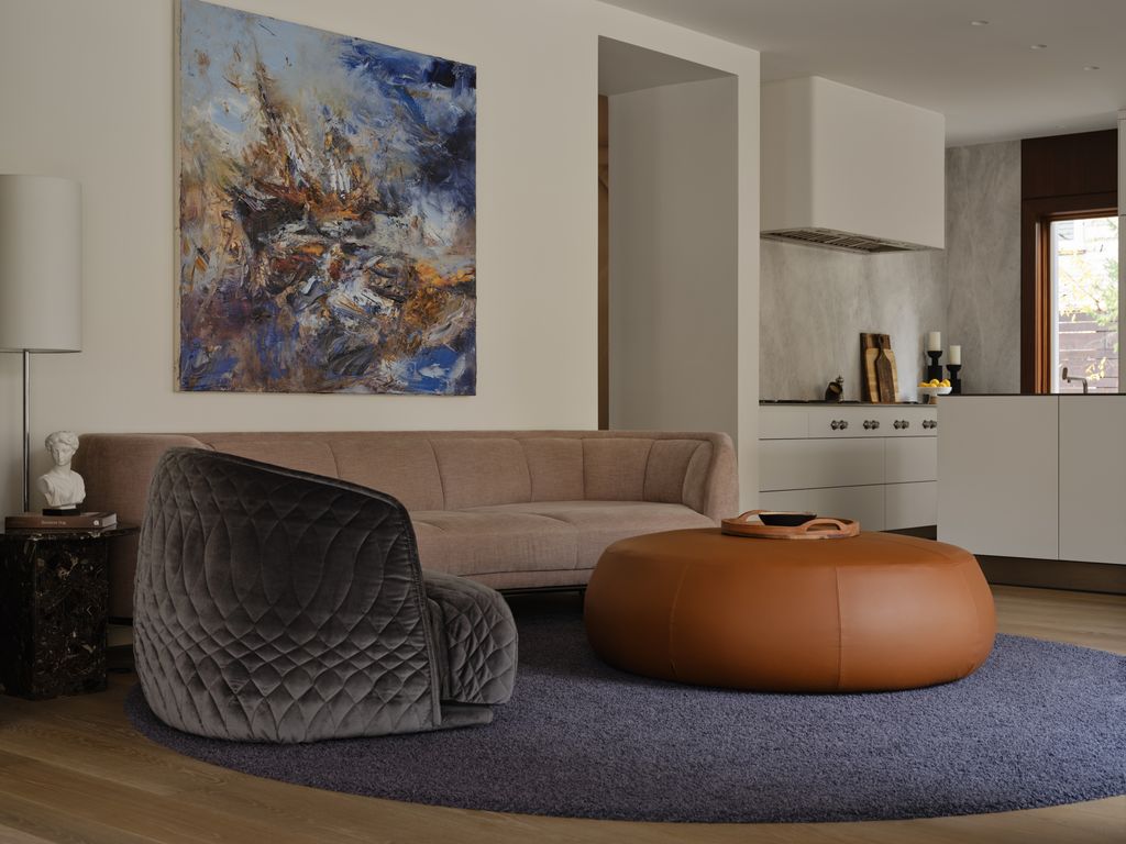 Salón con sofá beis y butaca de terciopelo azul oscuro