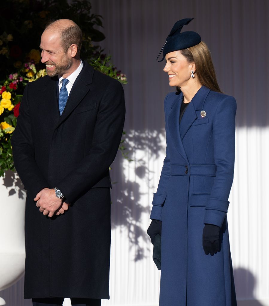 Kate con un vestido de Burberry con un abrigo azul de Sarah Burton para Alexander McQueen y pendientes que pertenecieron a Diana de Gales