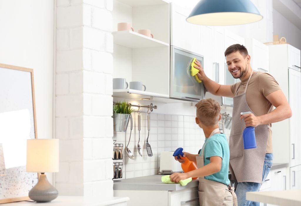 Padre e hijo limpiando la cocina. 