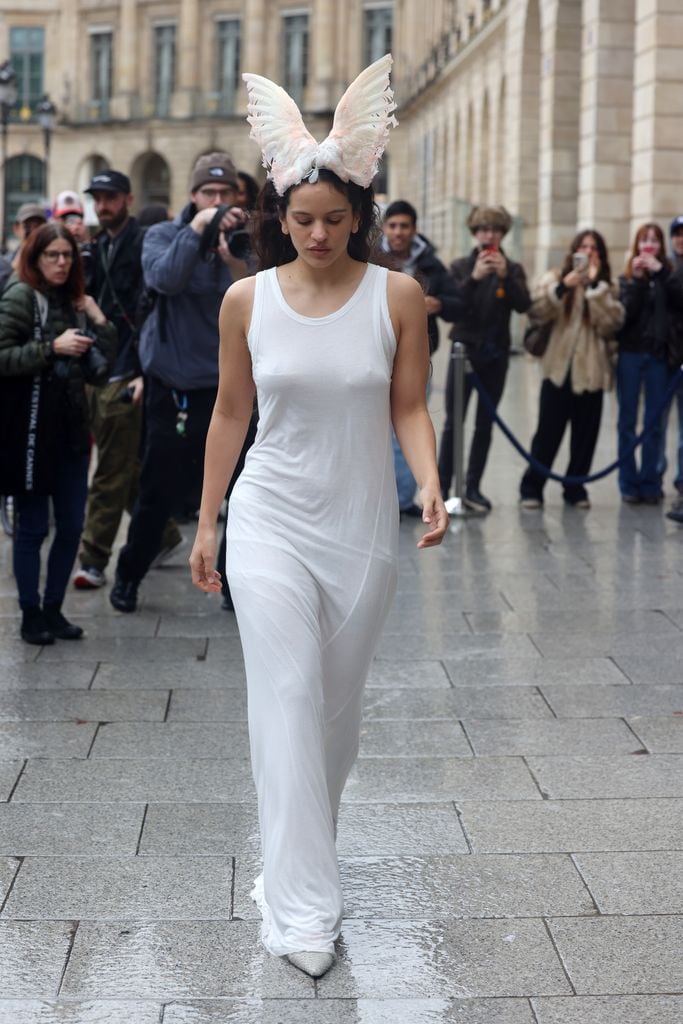Rosalia con vestido blanco de camino al desfile de Maison Margiela en la semana de la moda de París