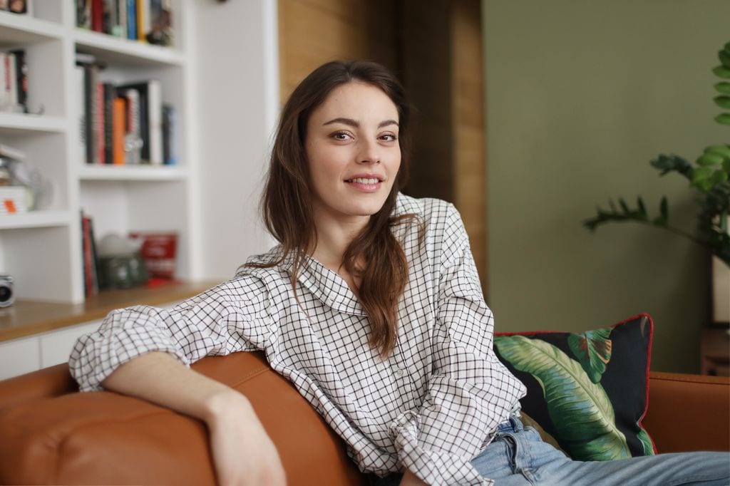 chica en el sofa sonriendo a camara