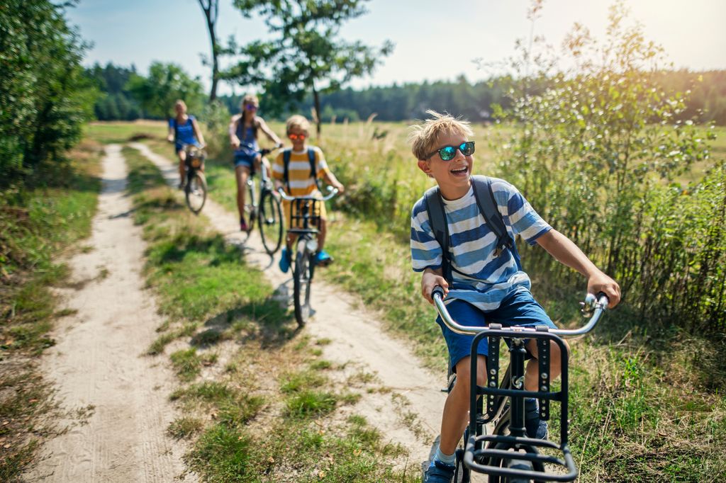 Paseo de niños en bicicleta por el campo en verano