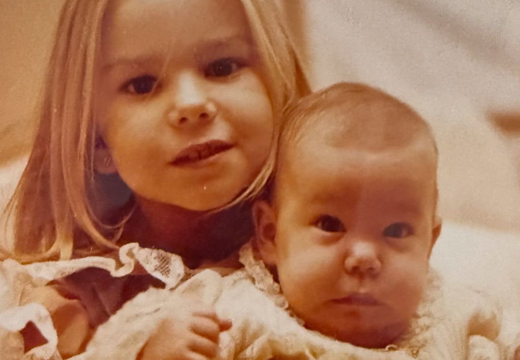 Caritina sujeta en brazos a su hermana pequeña, Carla