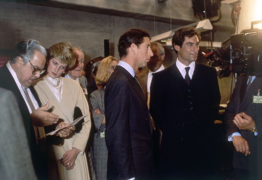El productor, junto al actor Timothy Dalton, reciben en el rodaje al príncipe Carlos con su entonces esposa, Diana de Gales