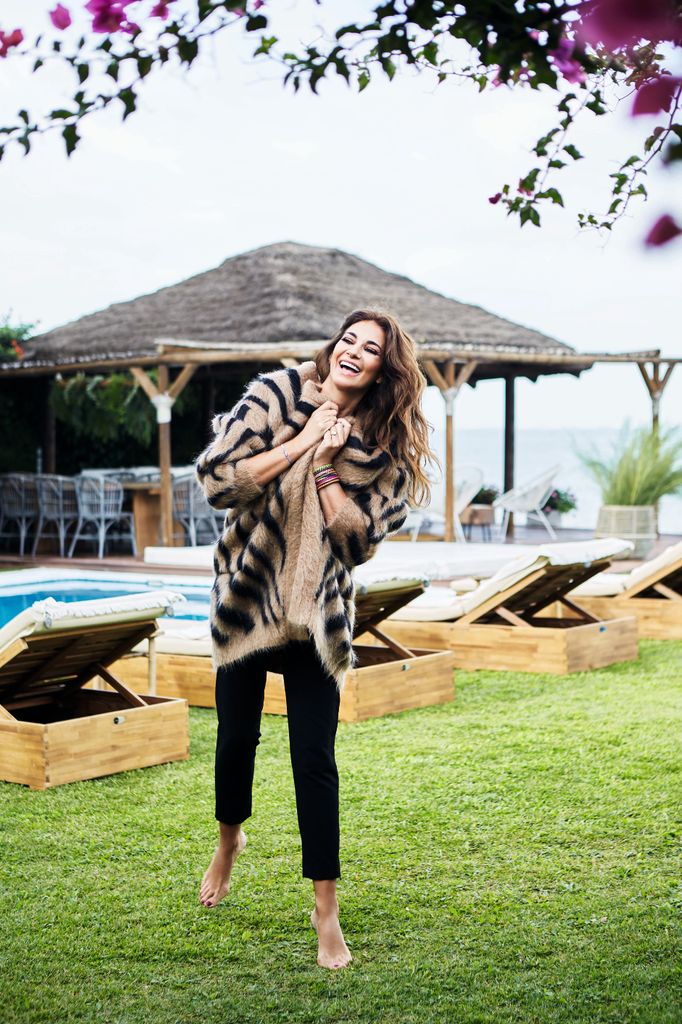 Mariló Montero posa espectacular en el jardín de casa de Sanlúcar de Barrameda. Risueña y descalza, la vemos al lado de las hamacas que están al lado de la piscina