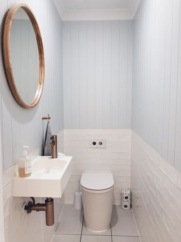 Baño con inodoro con cisterna empotrada.