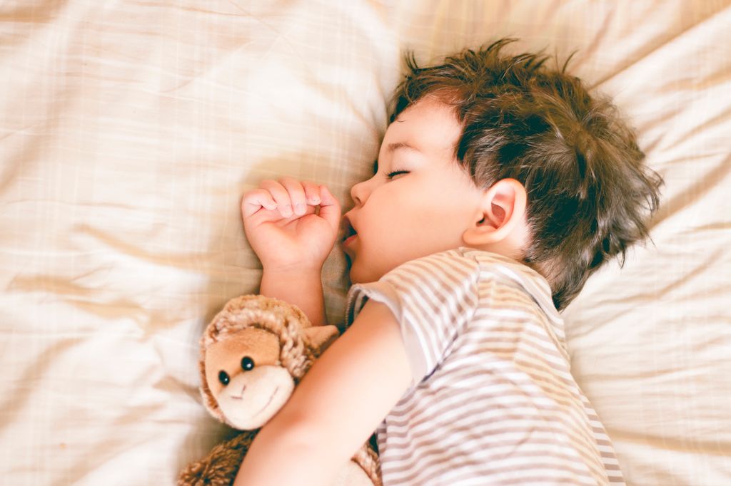 Niño pequeño dormido con la boca abierta
