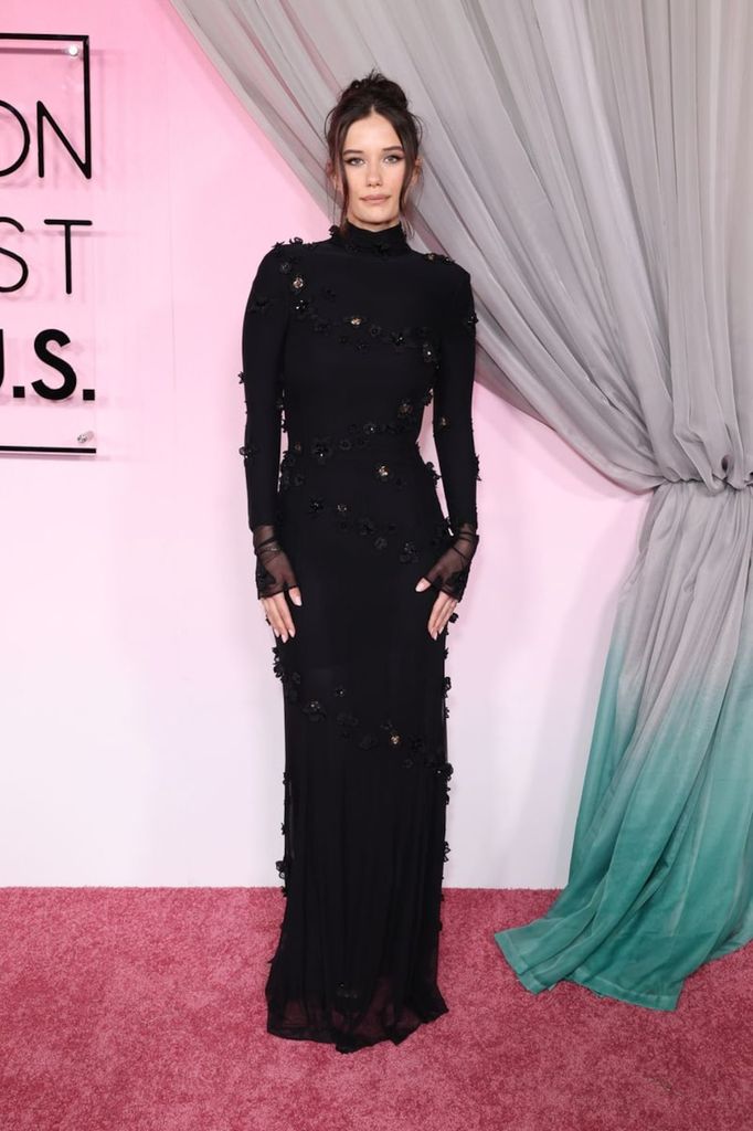 Vestida con un vestido negro largo de Blumarine, Ella Bleu Travolta apostó por un dramatismo sutil. El cuello alto y los delicados bordados florales aportaban al look una estética refinada, casi etérea.