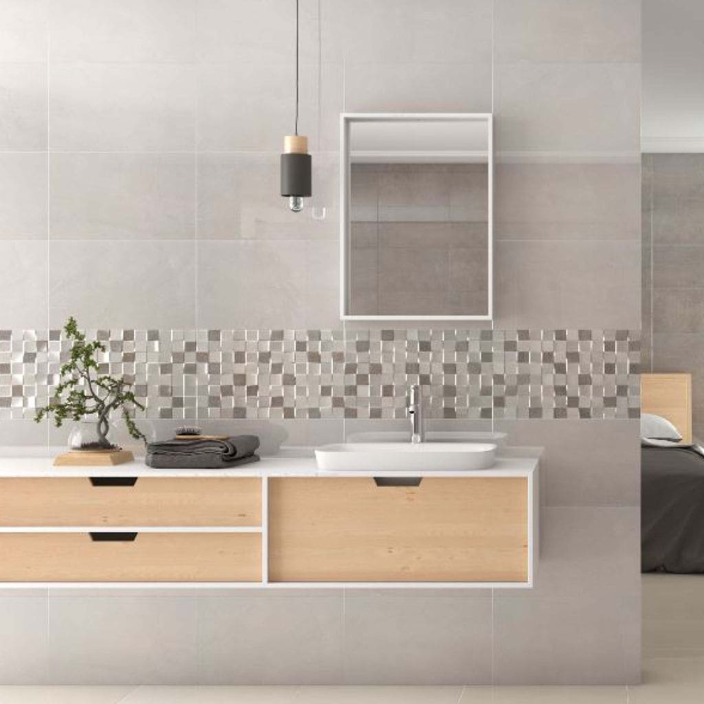 Baño con azulejo cerámico y cenefa en tonos grises