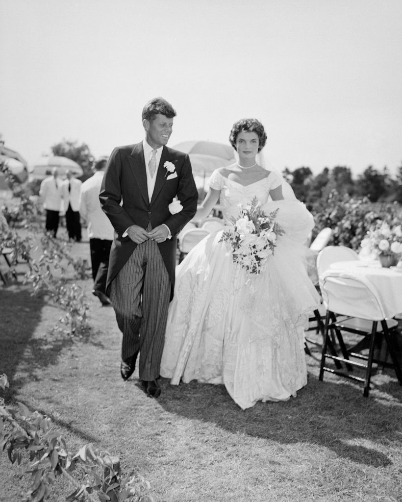 John F. Kennedy y Jacqueline Bouvier caminan juntos durante la recepción de su boda en Newport en 1953