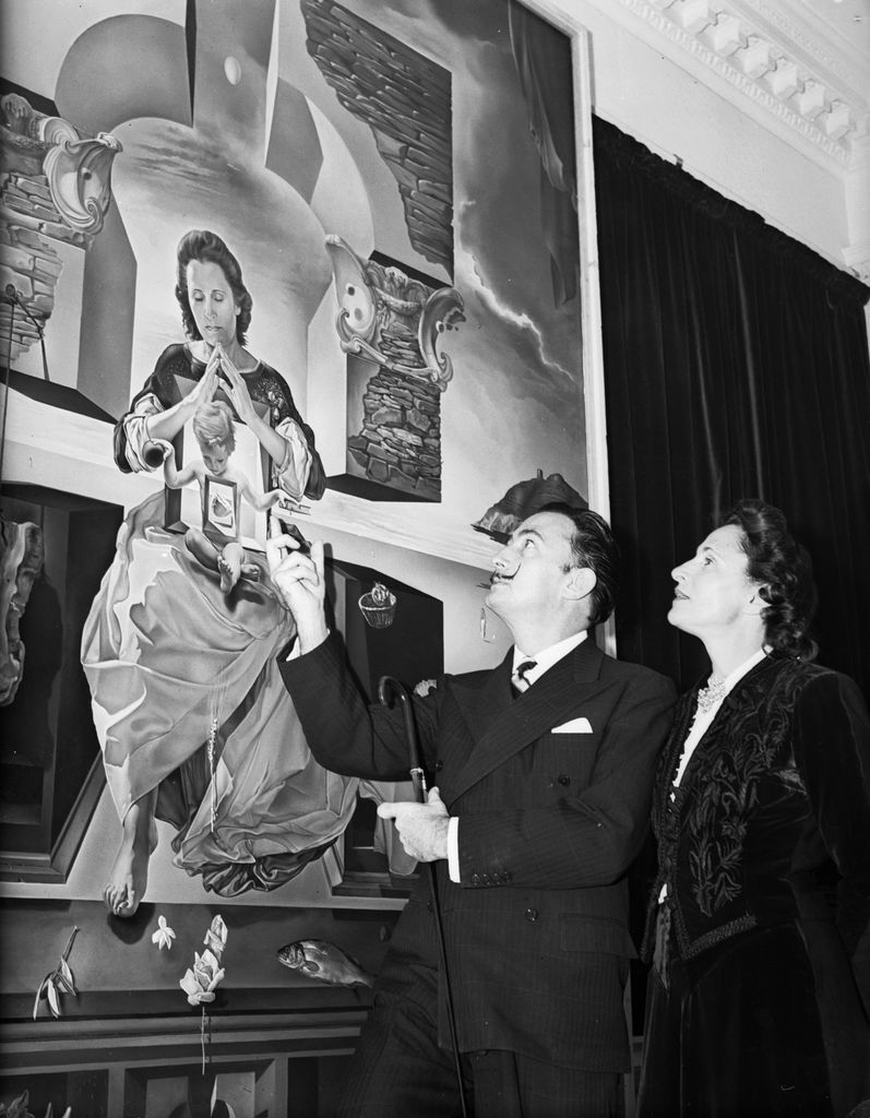 3rd December 1951: Spanish artist Salvador Dali (1904 - 1989) and his wife Gala (1894 - 1982) looking at one of his paintings, entitled 'The Madonna of Port Lligat'. Gala herself modelled for the figure of the Madonna. (Photo by Allan/Express/Getty Images)