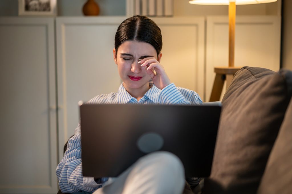 mujer mirando al ordenador con molestias en sus ojos
