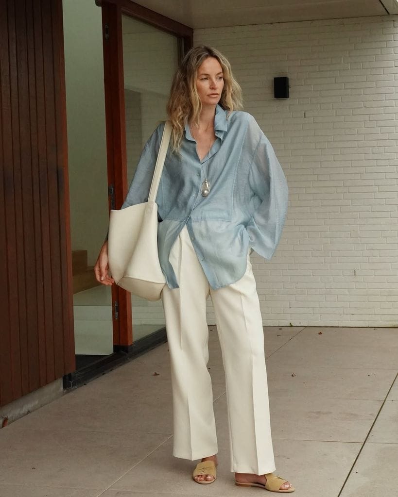 Influencer con camisa azul y pantalones blancos