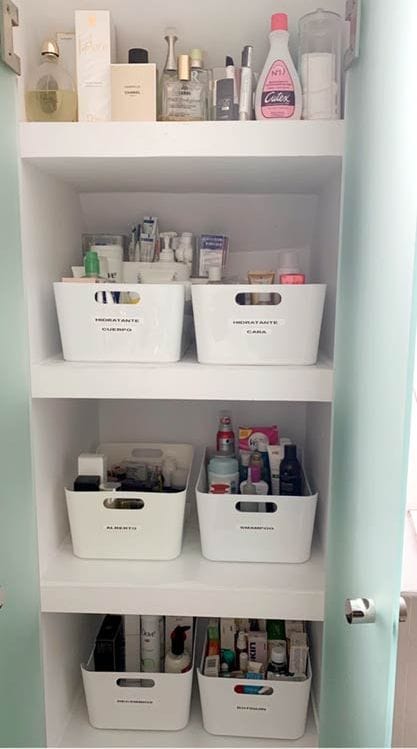 Armario de cuarto de baño con productos ordenados en cajas