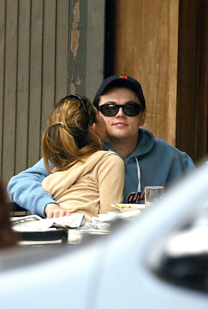 Plano medio de Leonardo Dicaprio y Gisele Bundchen en una cafetería