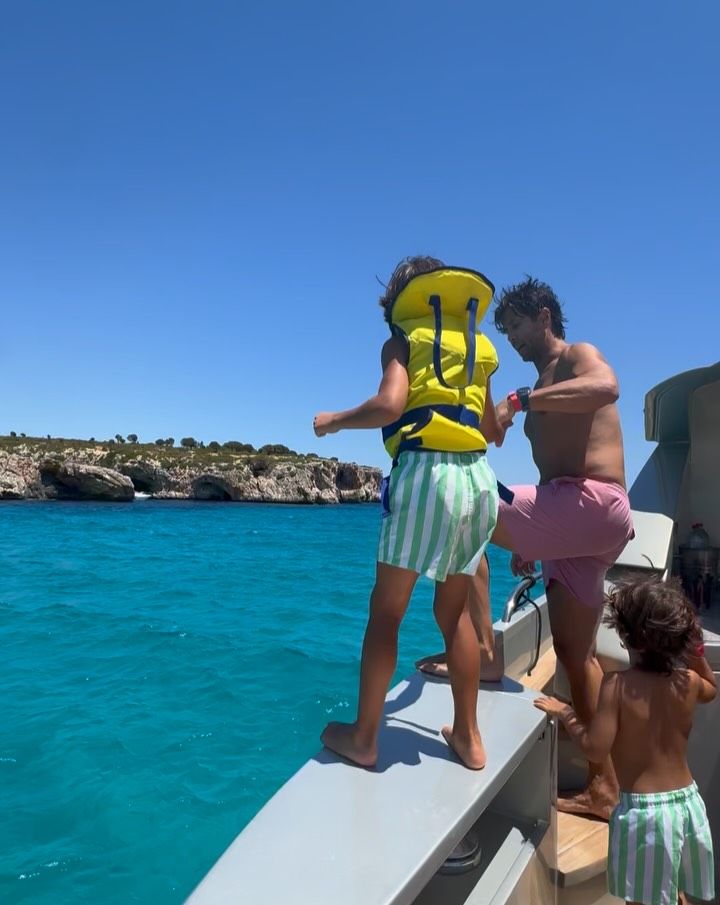 Fernando Verdasco saltando al agua con su hijo Miguel, de 7 años, mientras Mateo, de 5, les mira con atención