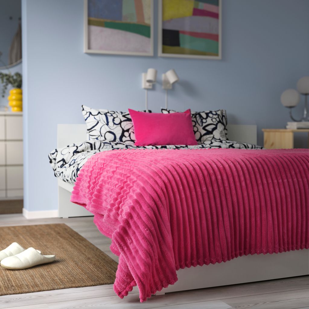 Cama con colcha de color fucsia de IKEA