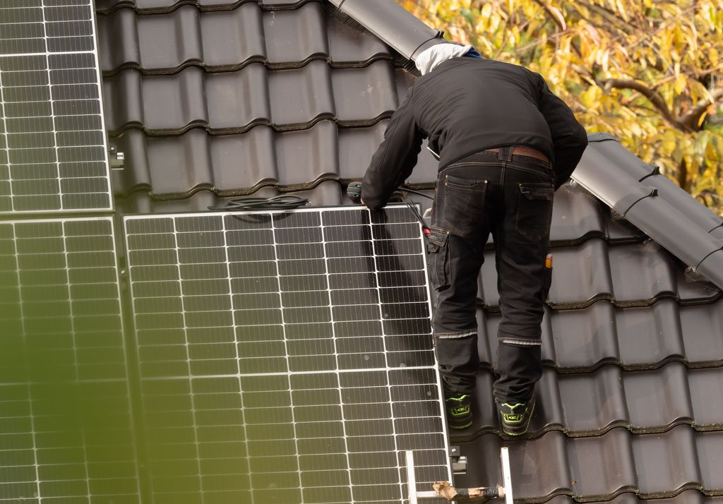 Instalando placa solar en el tejado de una casa