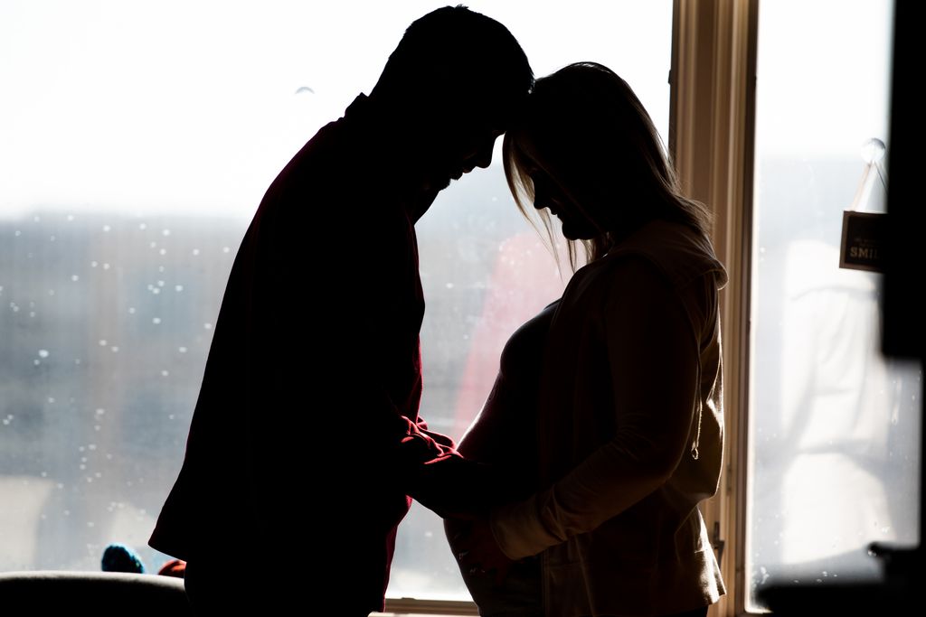 Pareja en gesto cercano con la madre embarazada