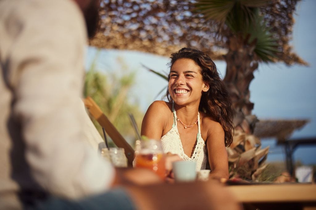 Mujer feliz cenando en la playa