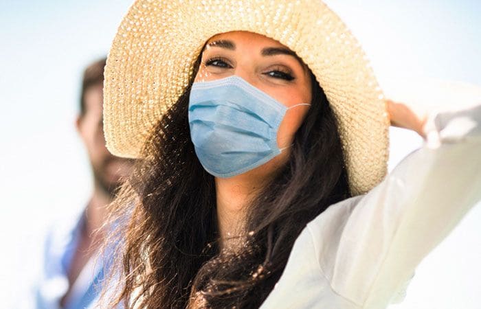 Chica con mascarilla en la playa
