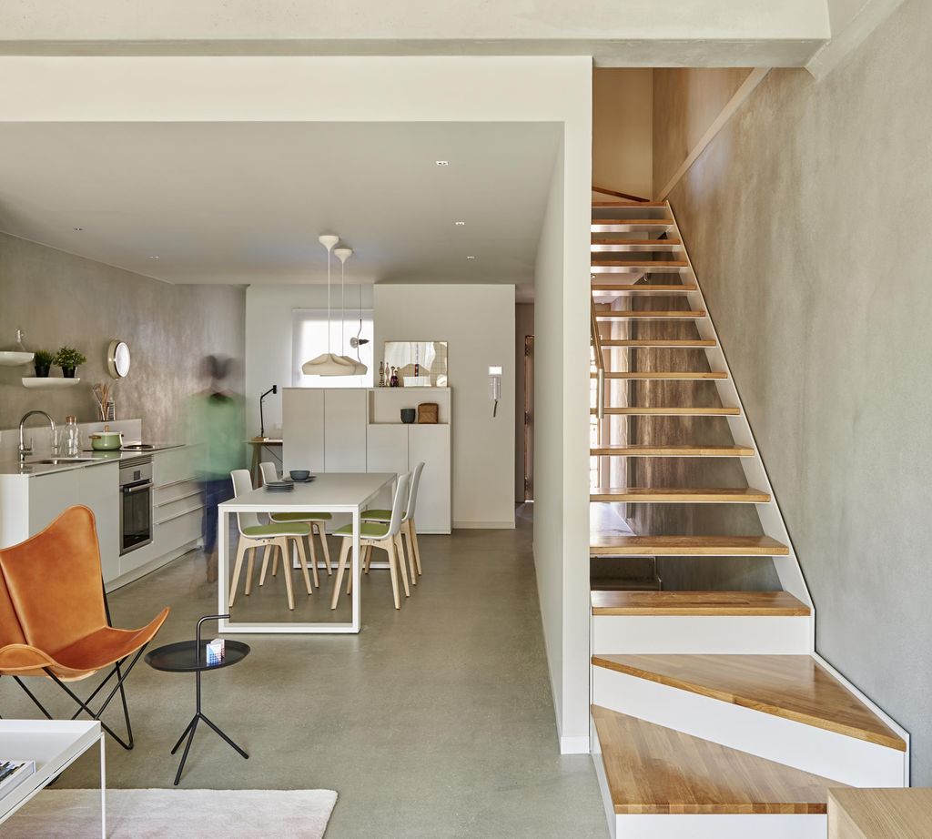 Salón, cocina y comedor, con escaleras de acceso a la zona de noche