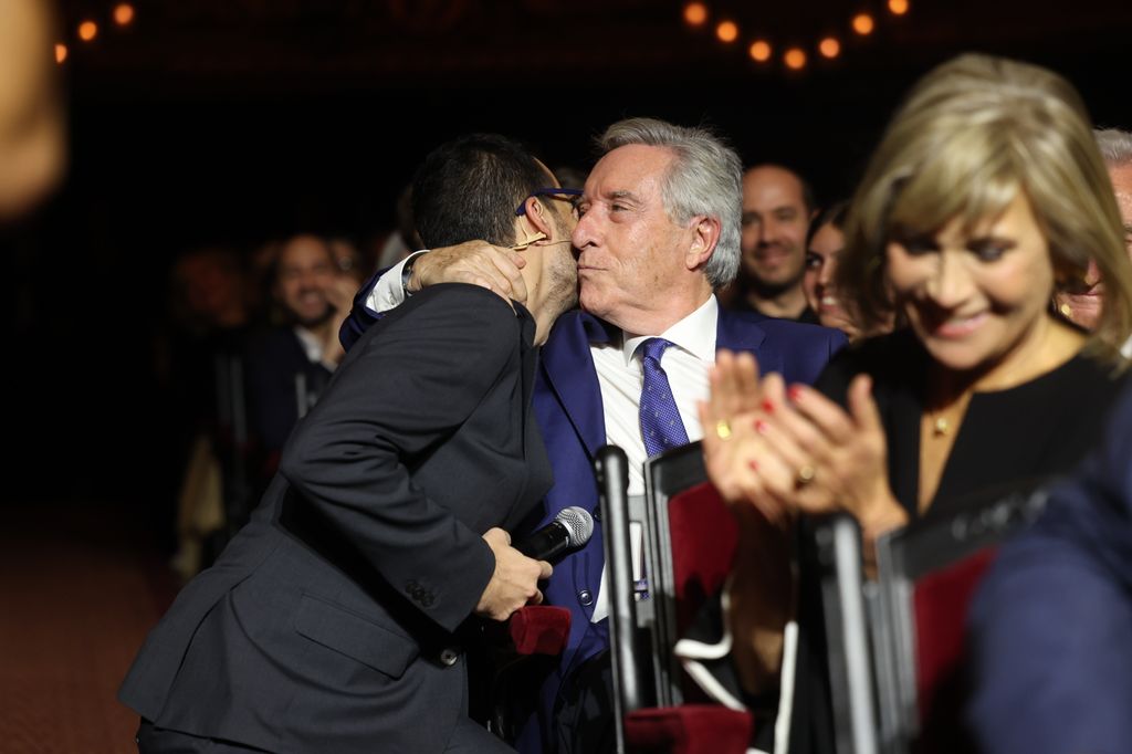 Plano medio de Iñaki Gabilondo dando un beso a José Luis Sastre entre el público