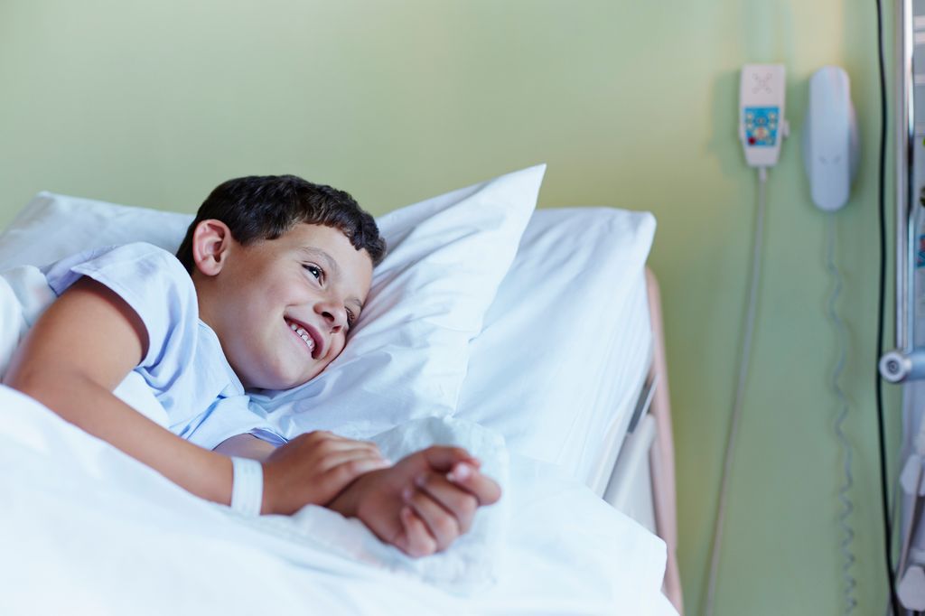 Niño en la cama del hospital sonriendo tranquilo