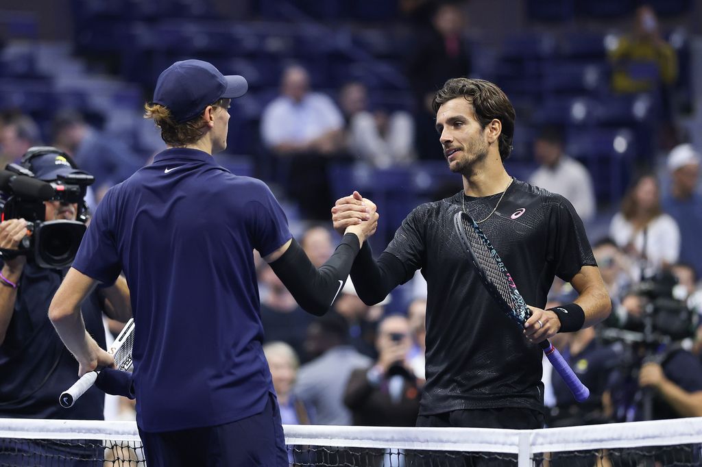 Lorenzo Musetti y Jannik Sinner se dan la mano para finalizar el partido.