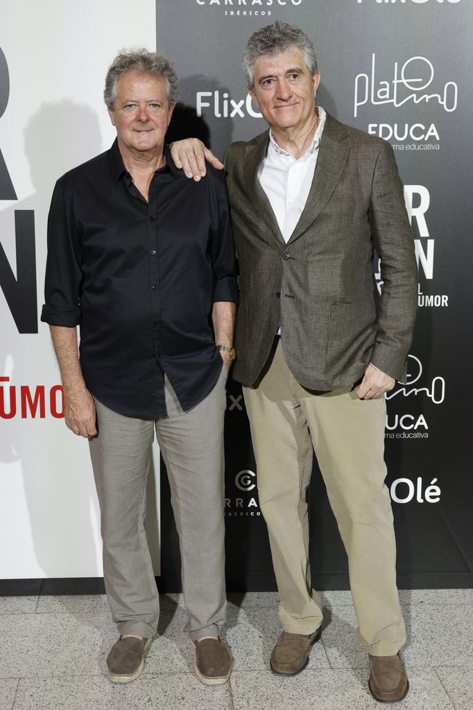 Guillermo Fesser y otro hombre posan juntos en un evento, ambos sonrientes.