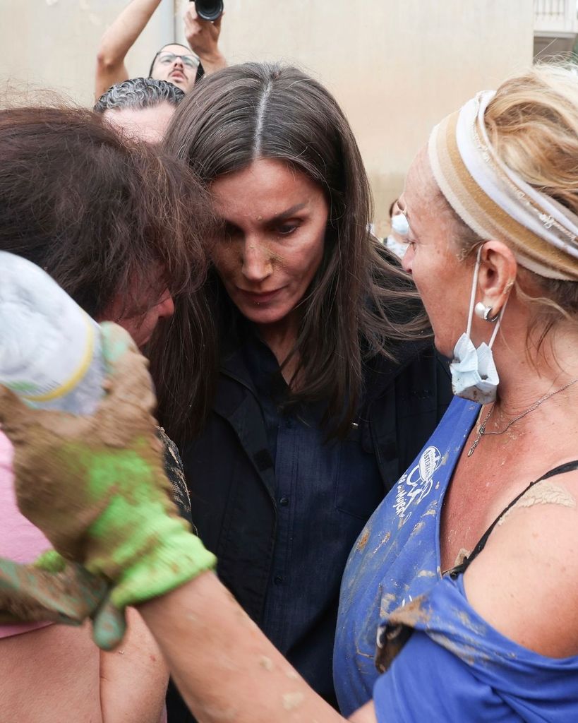 Plano medio de la Reina Letizia consolando a víctimas de la DANA