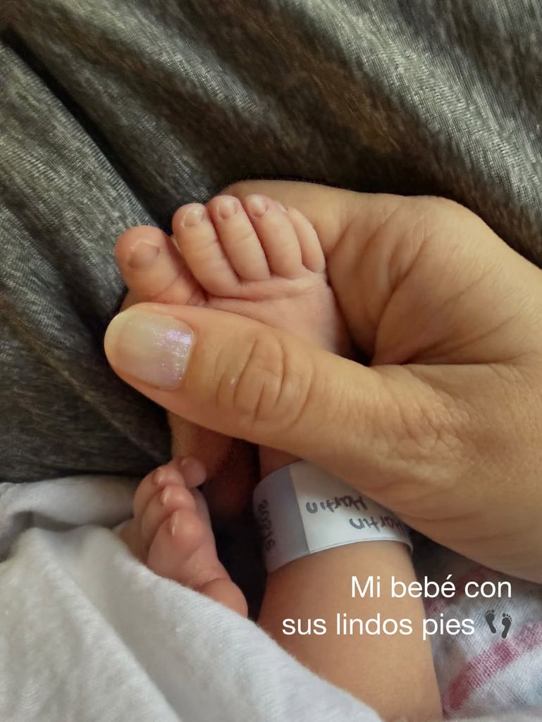 La feliz mamá está encantada con los piecitos de su hijo