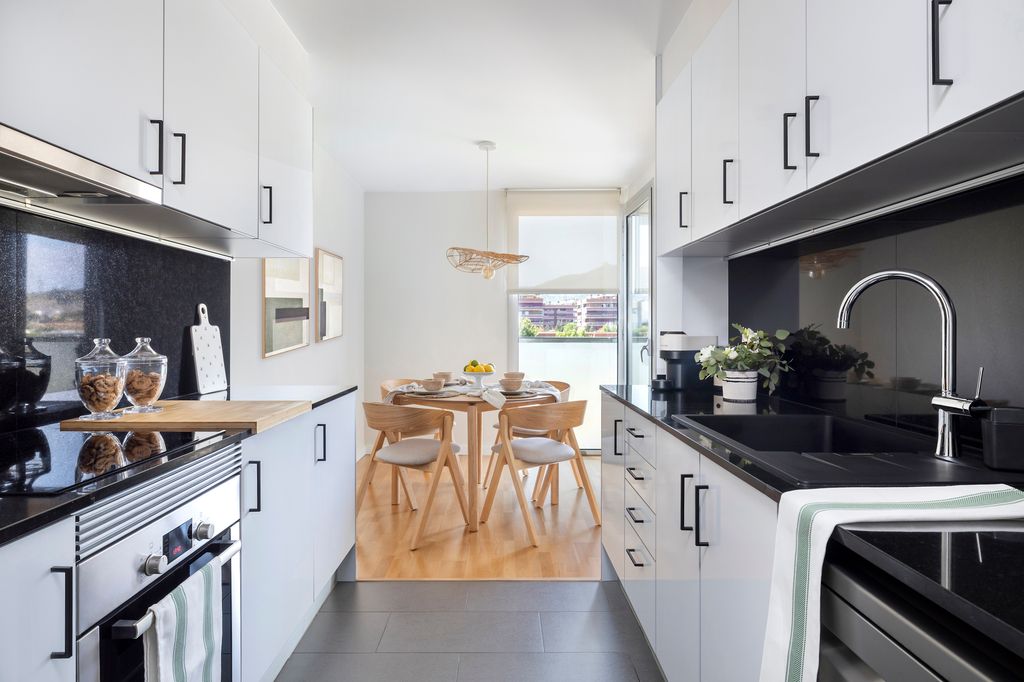 Cocina con armarios altos y bajos y 'office' al fondo