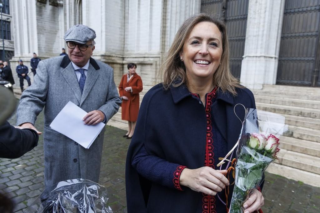 El príncipe Laurent saludando a la gente y su esposa, la princesa Claire, muy sonriente con unas flores que le han entregado