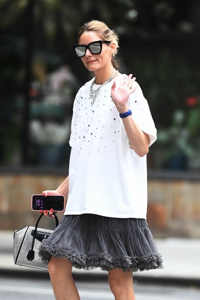 La modelo e influencer de moda Olivia Palermo luce una camiseta blanca cuadrada combinada con una falda gris esponjosa mientras va de compras por Nueva York.