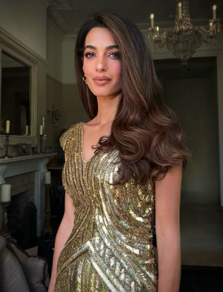 Amal Clooney con el pelo castaño oscuro con reflejos dorados y vestido de Alexandre McQueen