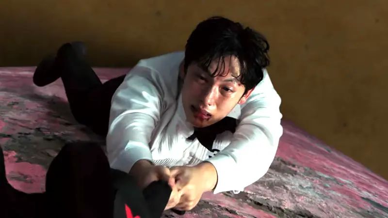 Tras enfrentarse a Gi-hun, Myung-gi qeuda suspendido agarrado de una chaqueta
