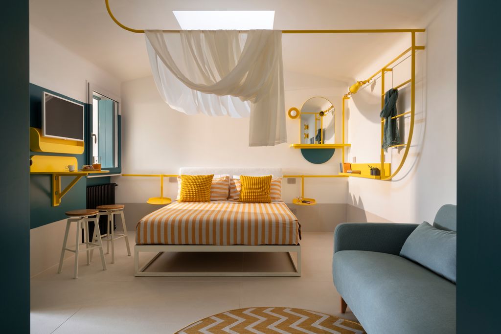 Sala polivalente de un pequeño estudio napolitano que alberga cocina, salón, comedor y dormitorio