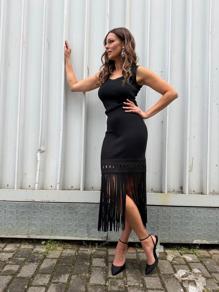 Eva González, elegante con vestido negro de punto con flecos.