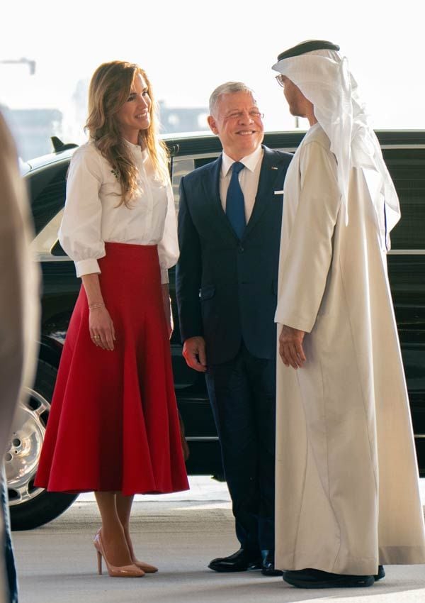 Rania de Jordania con falda roja y camisa blanca