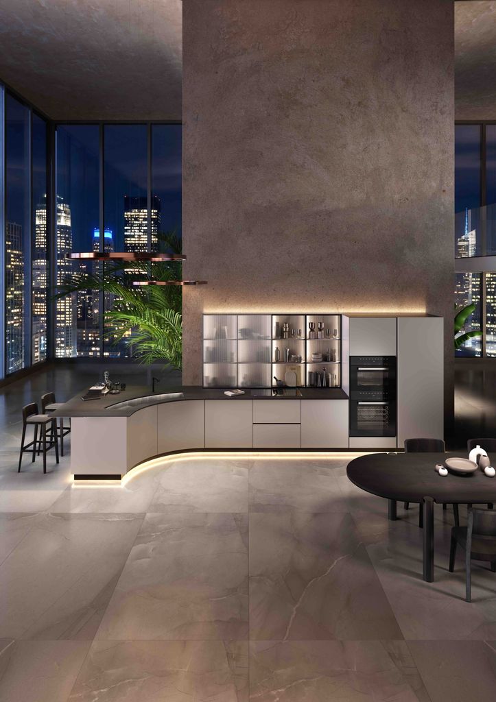 Cocina abierta al comedor con iluminación cálida y envolvente