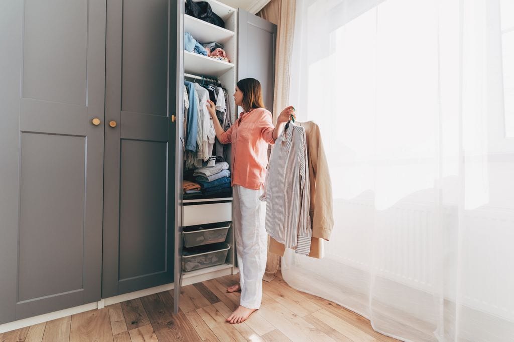 mujer descalza ordenando su armario