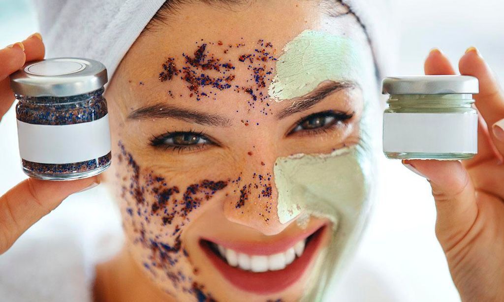 Joven feliz mostrando su crema exfoliante y su hidratante