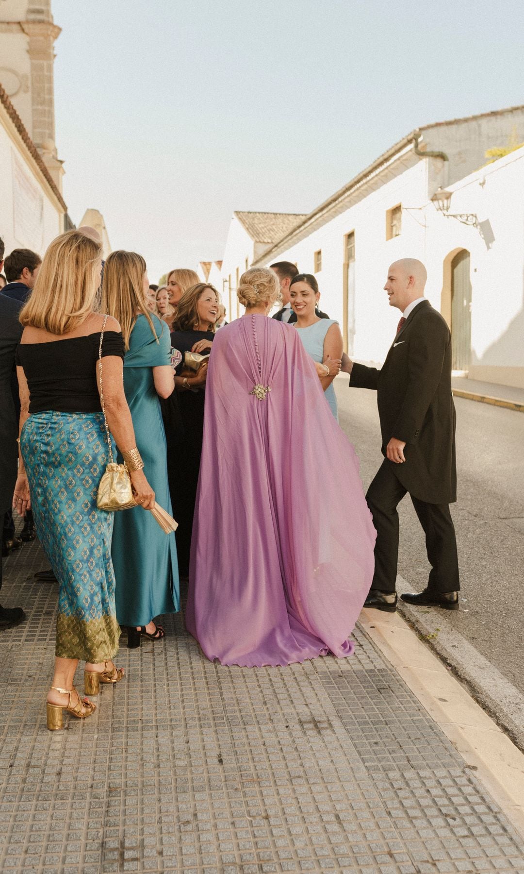 Madrina de boda con vestido satinado Elena Moore con capa desmontable