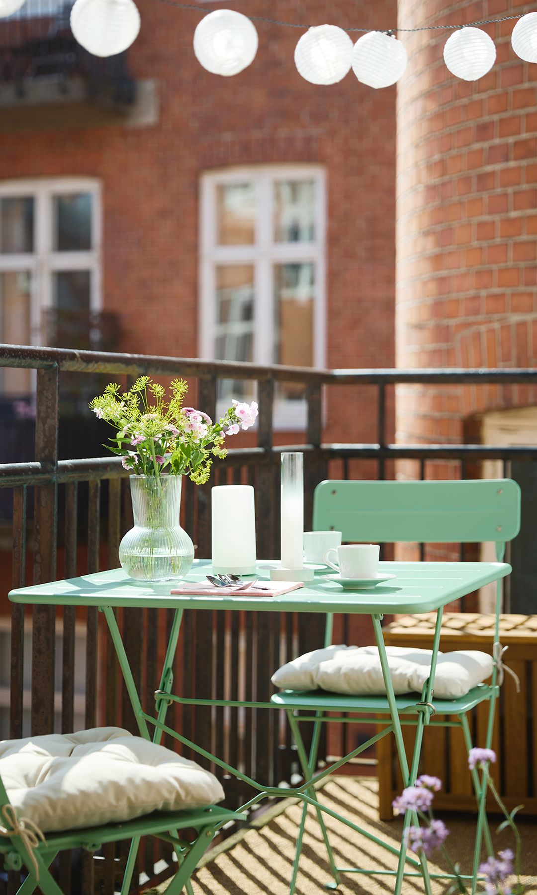 Terraza IKEA con mesa y sillas plegables verdes