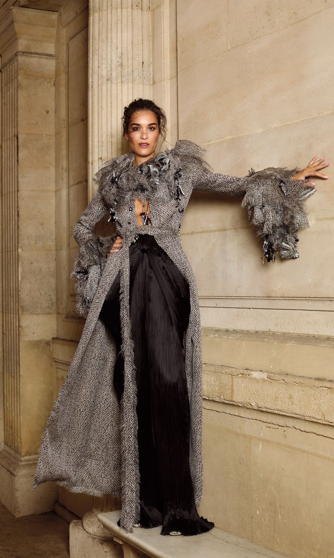 El gris y el negro comparten protagonismo en este look de alta costura de Dior, en el que un abrigo con cuello y mangas con volantes acompaña a un pantalón plisado formando un dúo de lo más sofisticado.
En la otra página, Bárbara posa con un diseño regio en terciopelo burdeos, de Giorgio Armani Privé.