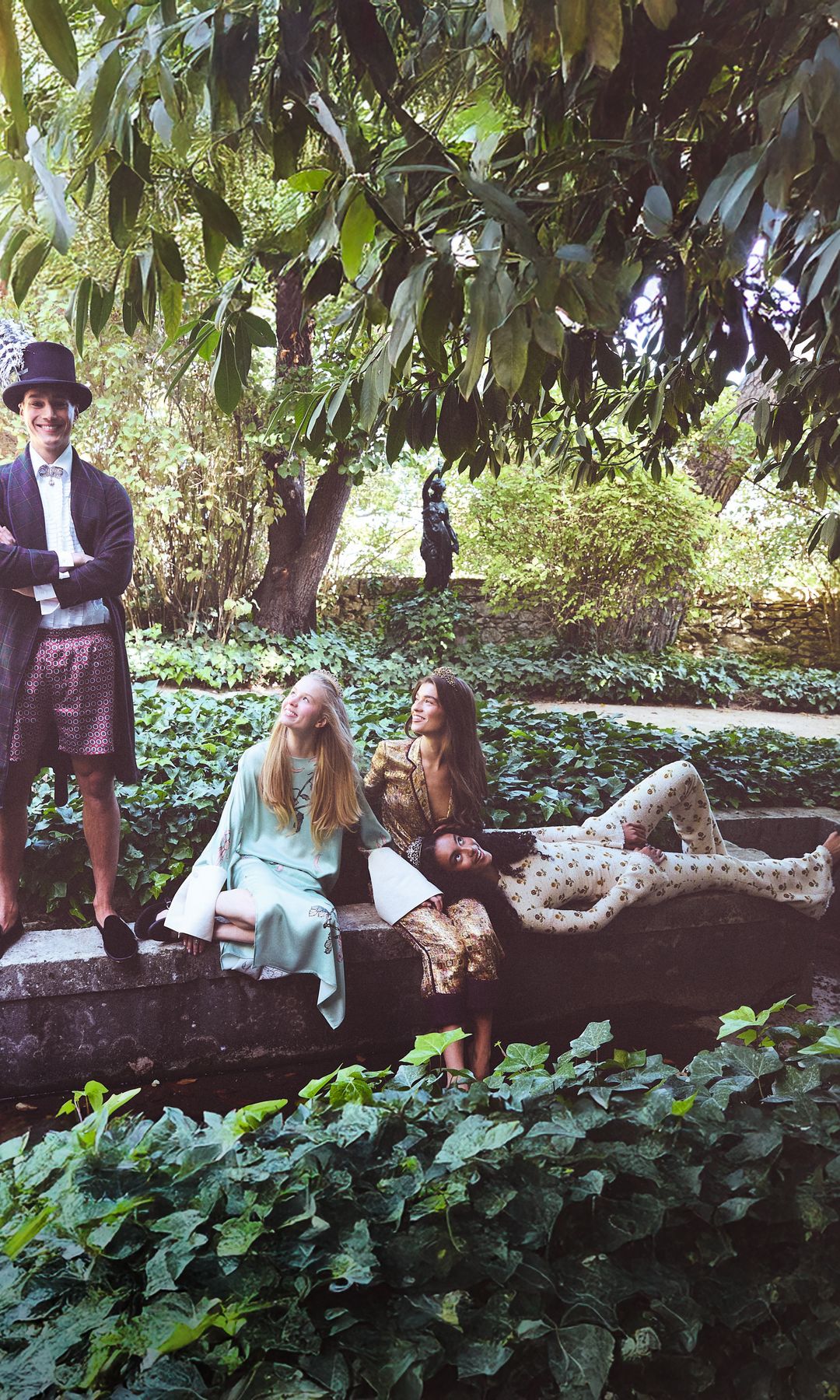 El modelo posa con bata, de El Corte Inglés; camisa, de Mans Concept; short vintage; zapatos, de Giorgio Armani, y sombrero, de Mimoki. 
A su lado, las modelos, con vestido azul, de Juan Vidal; zapatos, de Flabelus, y tiara, de Barcena. En el centro, con total look, de Jorge Acuña, y zapatos, de Lodi. A la derecha, la modelo lleva mono y zapatos, de Giambatistta Valli. Todas las joyas son de Barcena.