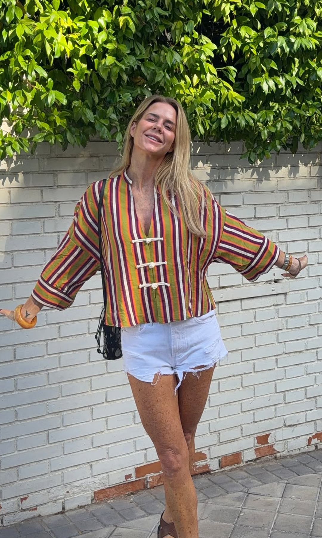 La nueva camisa de rayas de Amelia Bono se ve elegante hasta con 'shorts' muy cortos y sandalias planas