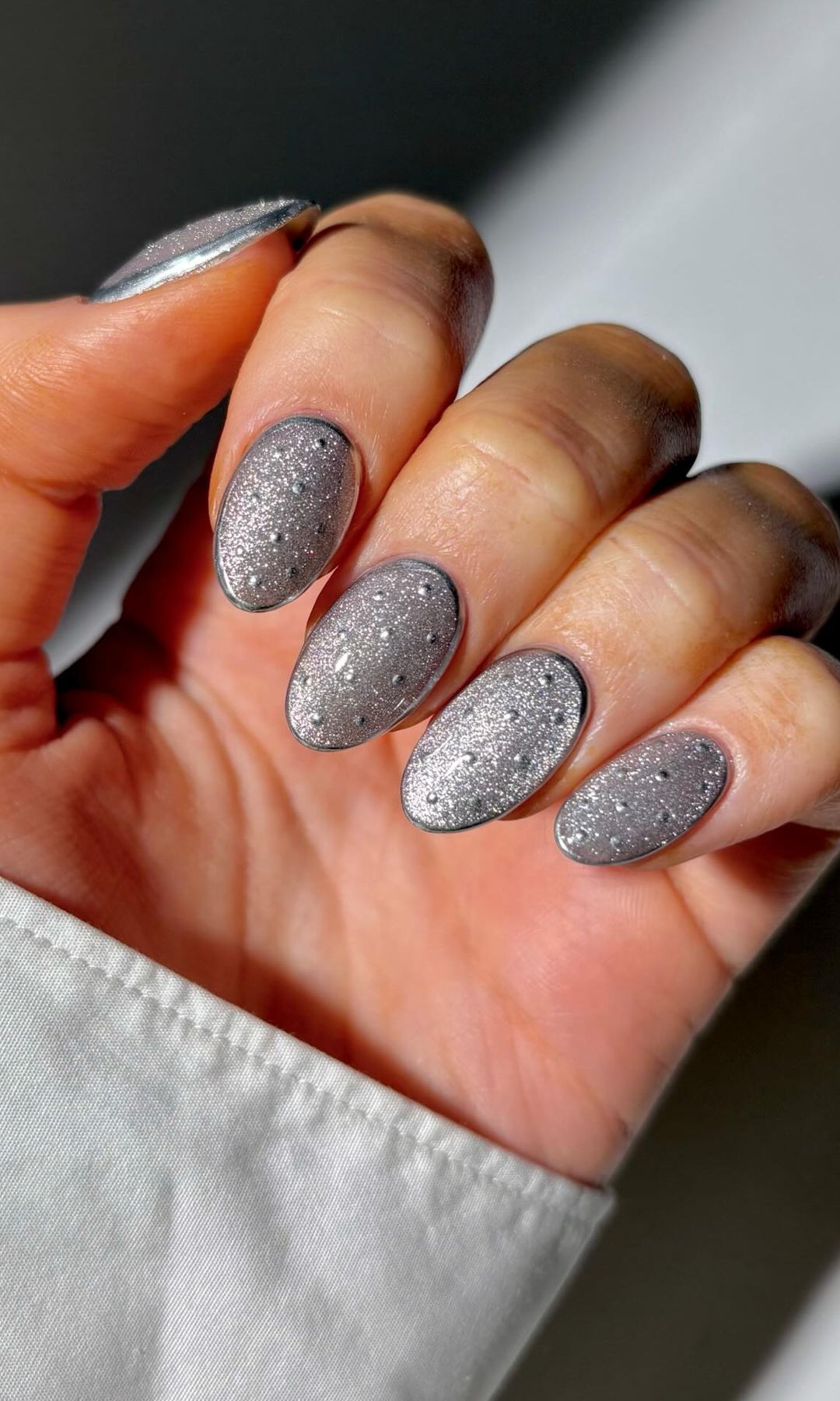 Manicura plateada con lunares y contorno