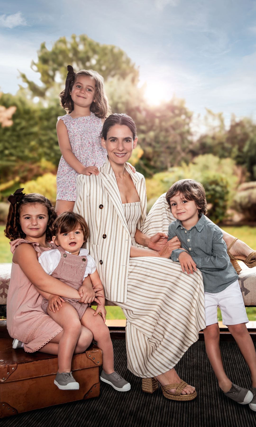 "Hay que saber priorizar y tener mucha organización", comenta Inés, en la imagen, con sus cuatro hijos: de izquierda a derecha, Inés (seis años), con vestido de Nícoli, sostiene a su hermano Beltrán (año y medio), con peto de Nícoli, camisa de Gocco y zapatos de Pisamonas; a su lado, Casilda (cuatro) lleva vestido de flores, de Paz Rodríguez, y Pelayo, bermudas de Paz Rodríguez, camisa de Nícoli y zapatos de Pisamonas. Por último, Inés madre, con vestido y americana de Max Mara y zapatos de Castañer